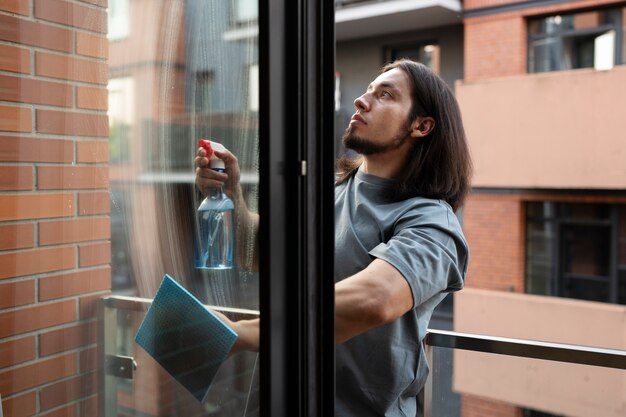 Seitenansicht Mann, der Fenster reinigt