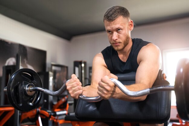 Seitenansicht Mann, der im Fitnessstudio trainiert