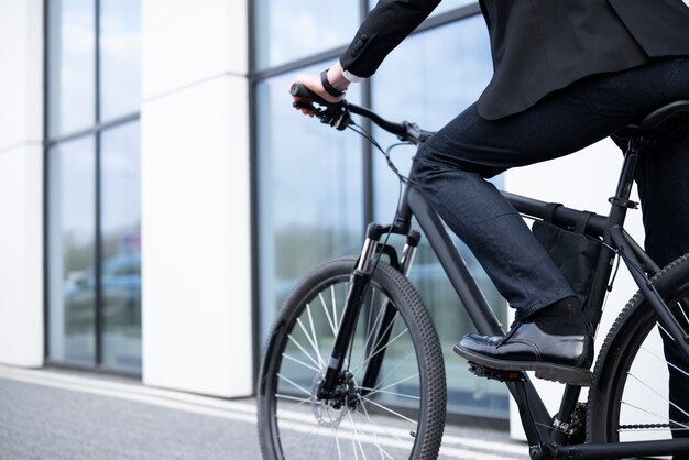 Seitenansicht Mann, der mit dem Fahrrad zur Arbeit geht