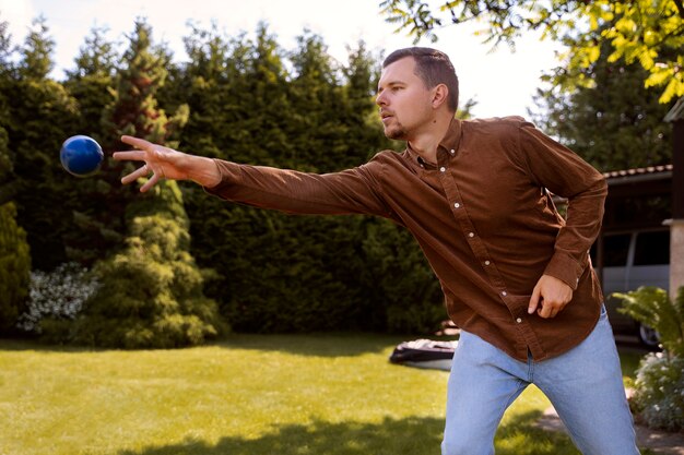 Seitenansicht Mann wirft Ball