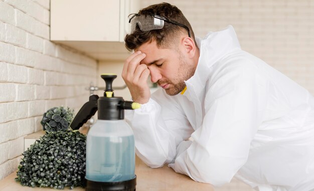 Kostenloses Foto seitenansicht müder mann mit desinfektionsmittel