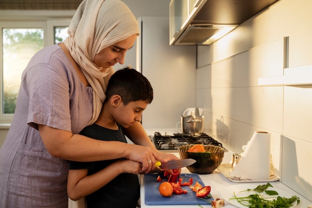 Kostenloses Foto seitenansicht mutter und junge beim kochen