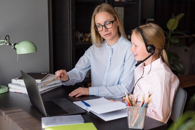 Seitenansicht Mutter und Tochter, die an einem Online-Kurs teilnehmen