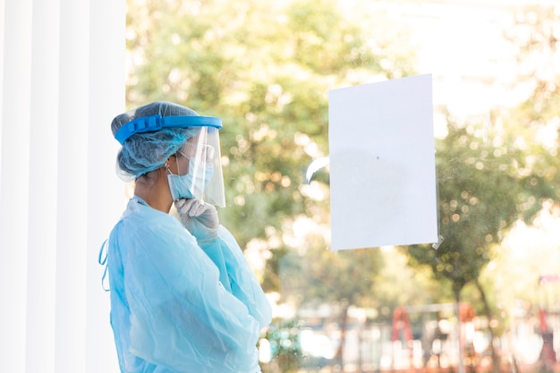 Kostenloses Foto seitenansicht nachdenkliche ärztin in schutzkleidung