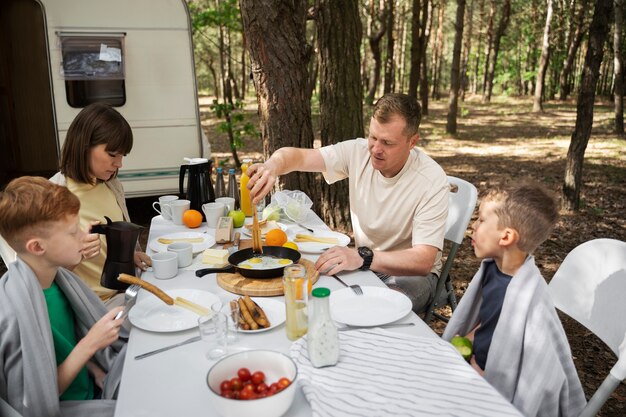 Seitenansicht Nomadenfamilie am Tisch sitzen