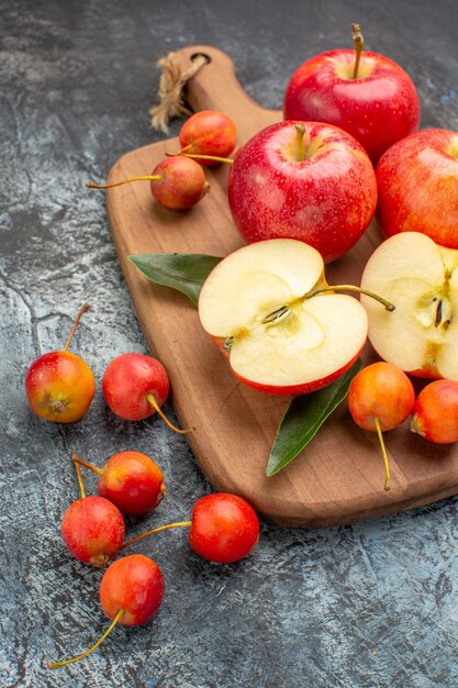 Seitenansicht Äpfel Kirschen rote Äpfel mit Blättern auf dem Holzbrett