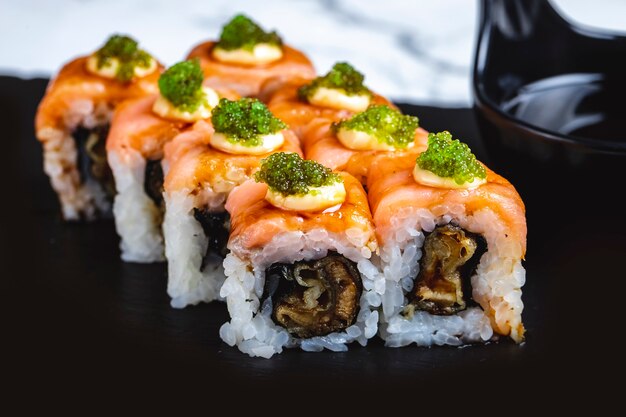 Seitenansicht Philadelphia Roll mit Lachssauce gebratenem Fisch und Tobiko-Kaviar an der Spitze