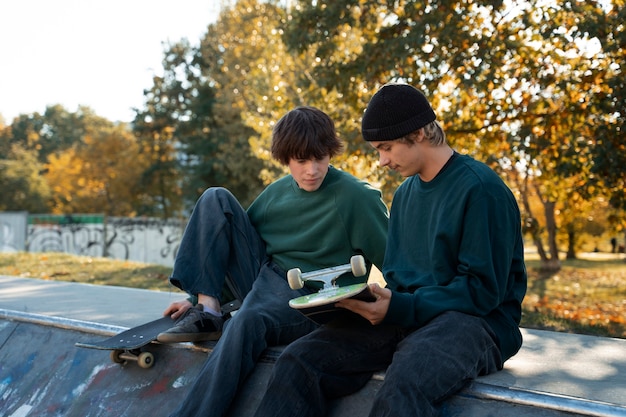 Kostenloses Foto seitenansicht rebellischer teenager mit skateboards