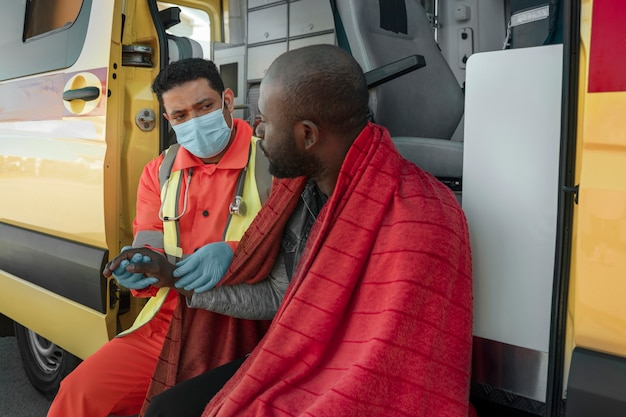 Kostenloses Foto seitenansicht sanitäter, der den patienten überprüft