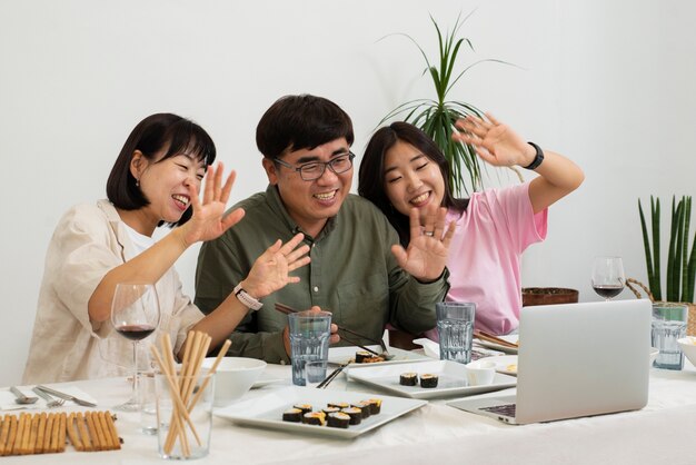 Seitenansicht-Smiley-Familie, die mit Laptop isst