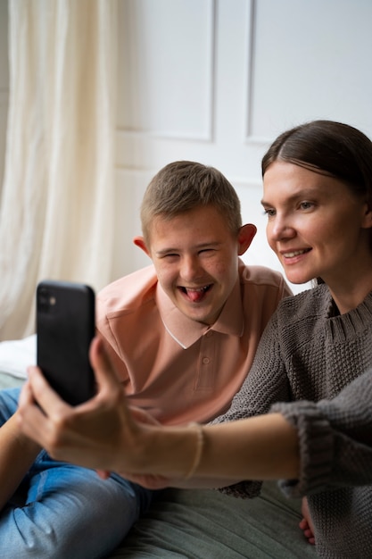 Seitenansicht Smiley-Frau und Junge, die ein Selfie machen