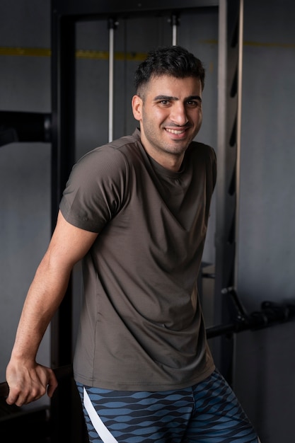 Kostenloses Foto seitenansicht-smiley-mann im fitnessstudio