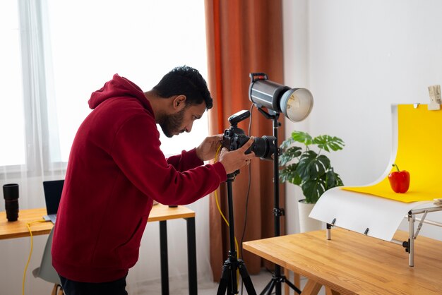 Seitenansicht spezialisierter Fotograf, der im Studio arbeitet