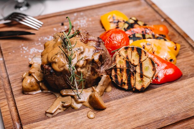 Seitenansicht Steak Medaillon in Pilzsauce und gegrilltem Gemüse