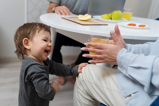 Seitenansicht süßes Kind, das sich an den Knien der Mutter festhält