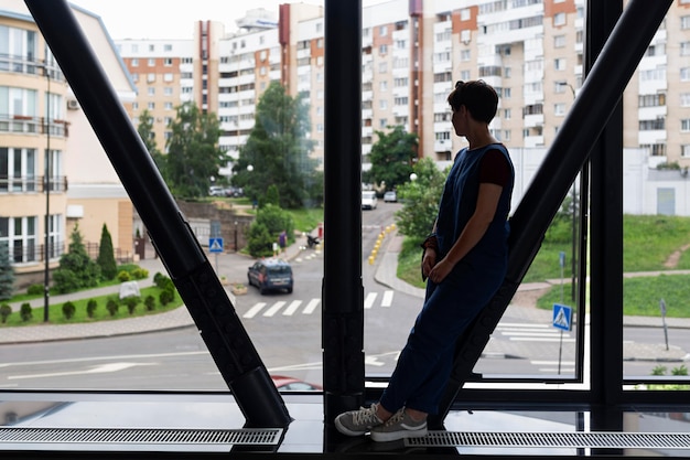 Kostenloses Foto seitenansicht teen, der aus dem fenster schaut