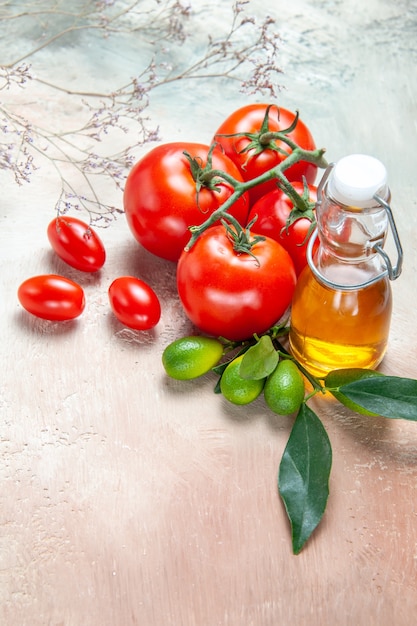 Seitenansicht Tomaten Flasche Öl Tomaten mit Stiel Zitrusfrüchten mit Blättern