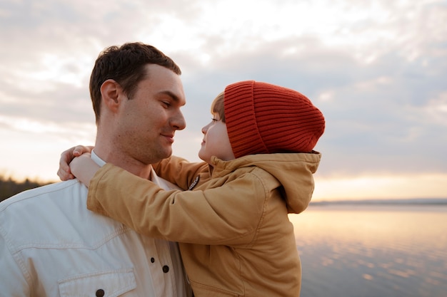 Kostenloses Foto seitenansicht: vater und sohn hängen auf einem steg herum