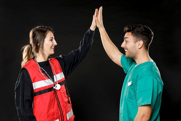 Kostenloses Foto seitenansicht von arzt und sanitäter, die sich gegenseitig hochficken