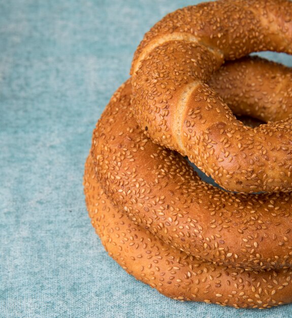 Seitenansicht von Bagels auf der rechten Seite und blauem Hintergrund mit Kopienraum