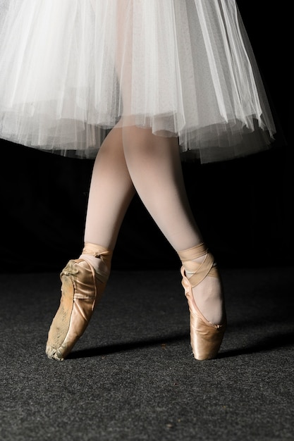 Kostenloses Foto seitenansicht von ballerinafüßen in spitzenschuhen und in ballettröckchenkleid