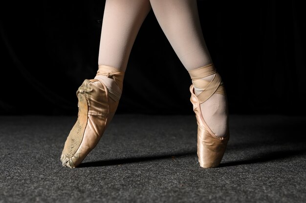 Seitenansicht von Ballerinafüßen in Spitzenschuhen und in Strumpfhosen