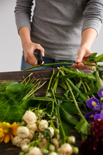 Seitenansicht von Blumen, Florist, der Stiel schneidet.