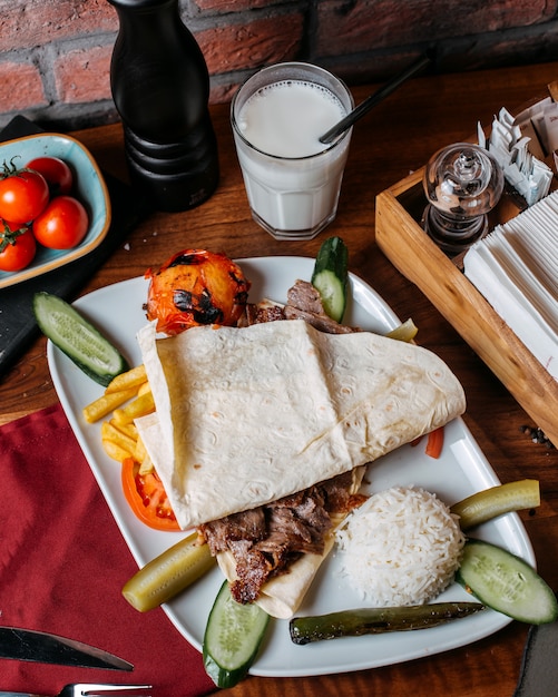 Seitenansicht von Dönerfleisch mit Pommes Frites Reis und Gemüse auf Teller