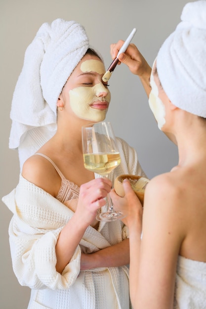 Seitenansicht von Frauen, die zu Hause Gesichtsmasken anwenden