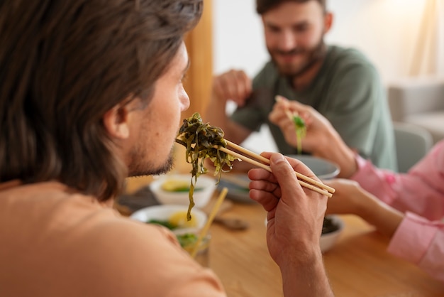 Kostenloses Foto seitenansicht von freunden, die algensnacks essen