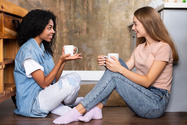 Seitenansicht von Freundinnen, die ein Gespräch über Kaffee haben