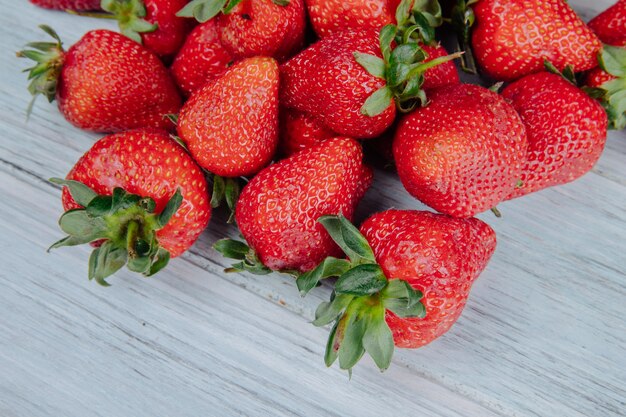 Seitenansicht von frischen reifen Erdbeeren auf weißem Holz