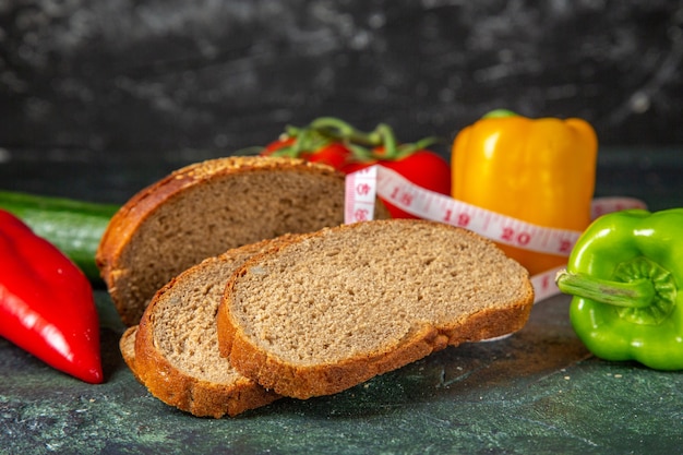 Seitenansicht von ganzem frischem Bio-Gemüse und Meter Schwarzbrotscheiben