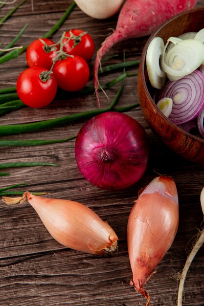 Seitenansicht von Gemüse als Schalottenzwiebeltomate und andere auf hölzernem Hintergrund