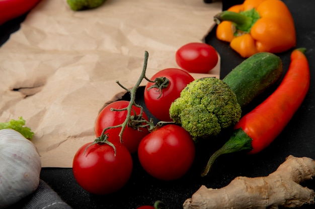 Seitenansicht von gemüse als tomatenbrokkoli-pfeffer und andere auf schwarzem hintergrund mit kopienraum