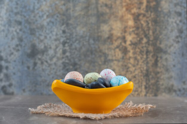 Seitenansicht von hellen bunten Steinbonbons in orangefarbener Schüssel.