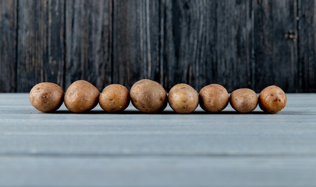Seitenansicht von Kartoffeln auf Holzoberfläche und Hintergrund mit Kopienraum 3