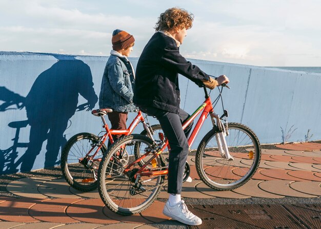 Seitenansicht von Kindern, die zusammen Fahrrad draußen fahren