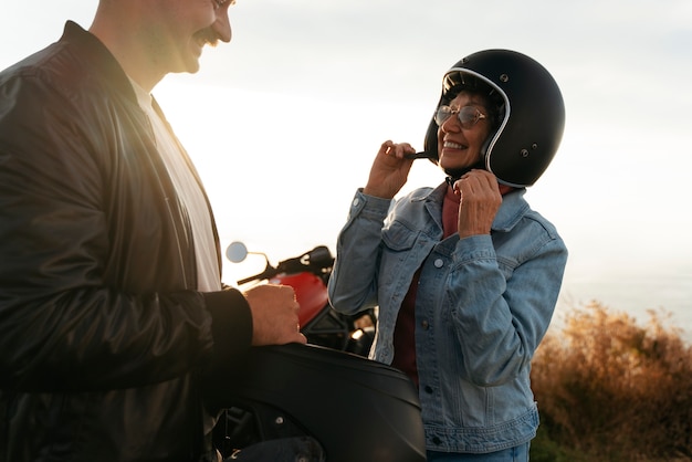 Kostenloses Foto seitenansicht von menschen mit motorrad im freien