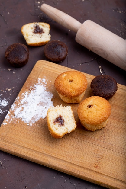 Seitenansicht von Muffins mit Schokolade auf einem hölzernen Schneidebrett