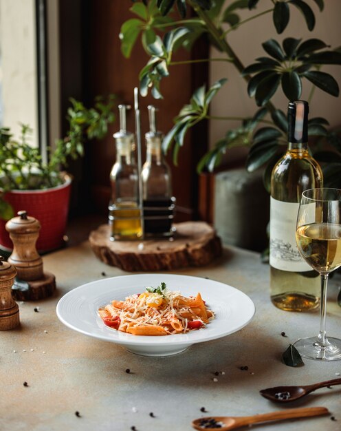 Seitenansicht von Nudeln mit Tomatensauce und Parmesan in weißer Schüssel