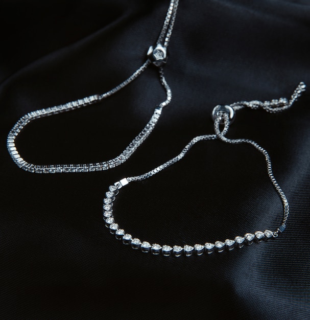 Kostenloses Foto seitenansicht von silberarmbändern mit diamanten auf schwarzer wand