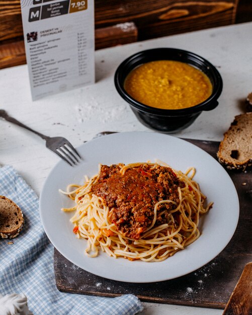 Seitenansicht von Spaghetti Bolognese auf weißem Teller