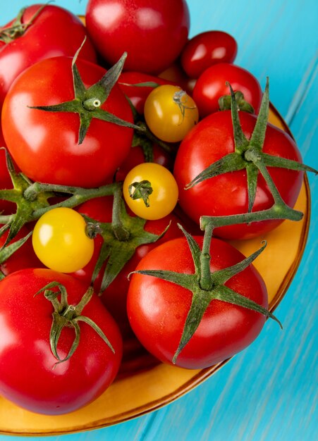 Seitenansicht von Tomaten in der Schüssel auf blauer Oberfläche