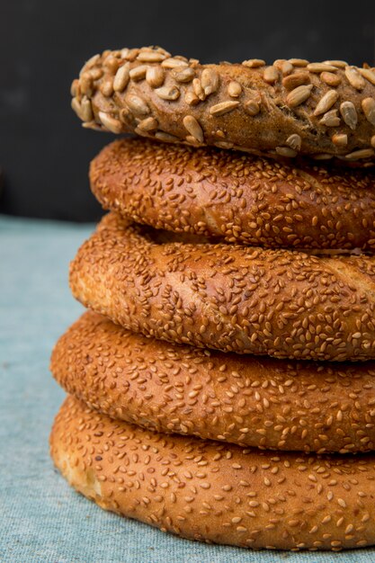 Seitenansicht von türkischen Bagels auf blauer Oberfläche und schwarzem Hintergrund