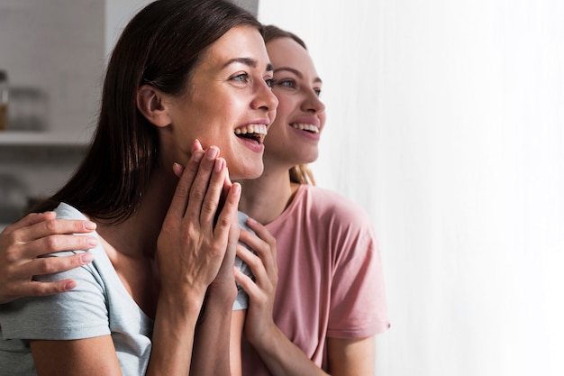 Seitenansicht von überraschten Frauen zu Hause mit Kopierraum