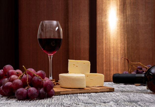 Seitenansicht Wein mit Traube und Käse auf weißem Holztisch und horizontal