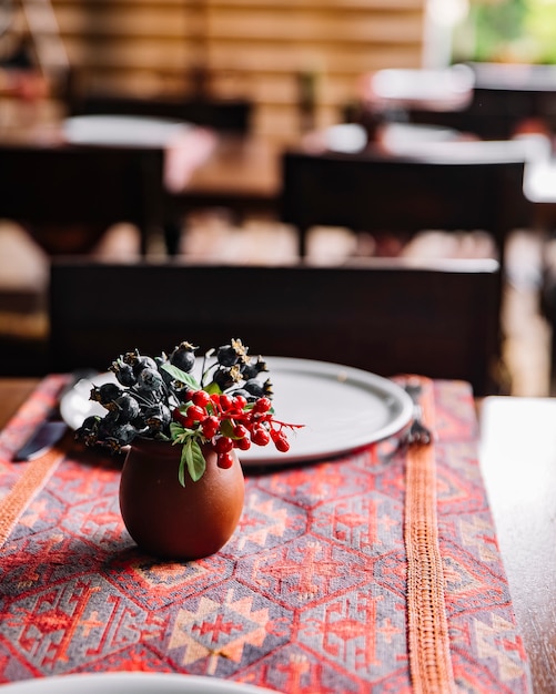 Seitenansicht wilde beeren in einem tontopf auf dem tisch