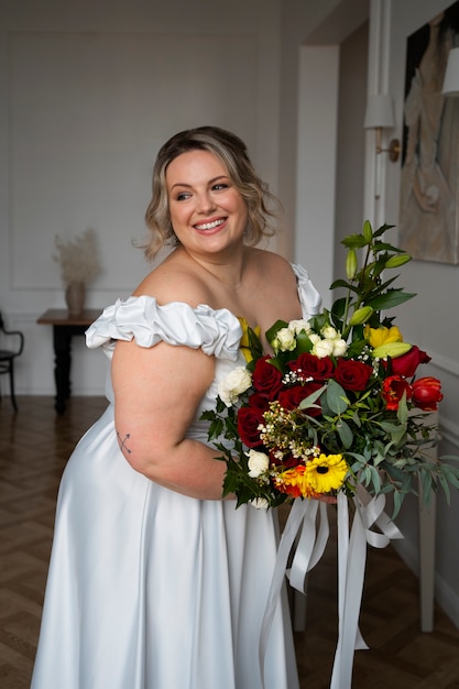 Kostenloses Foto seitenansichtbraut, die mit blumen aufwirft