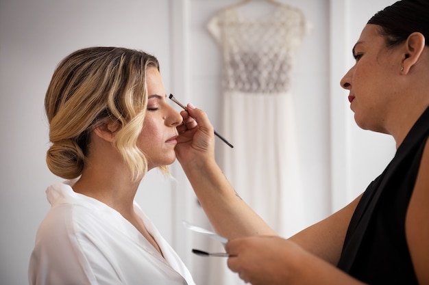 Kostenloses Foto seitenansichtbraut, die zur hochzeit fertig wird